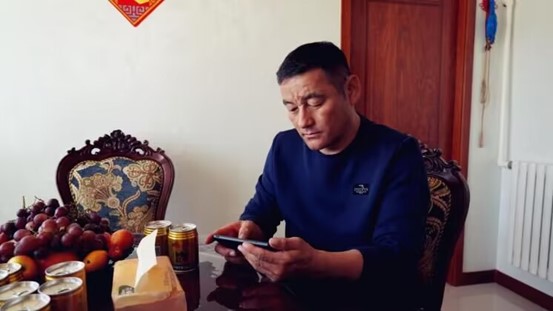 吉仁浩亞在手機(jī)屏幕上遠(yuǎn)程操作智慧羊棚