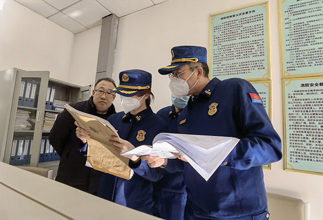 檢查人員實地查看檔案，了解防火巡查制度落實情況