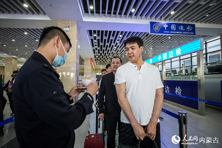 二連出入境邊防檢查站執(zhí)勤民警為旅客提供通關(guān)咨詢引導(dǎo)。胡富國(guó)攝