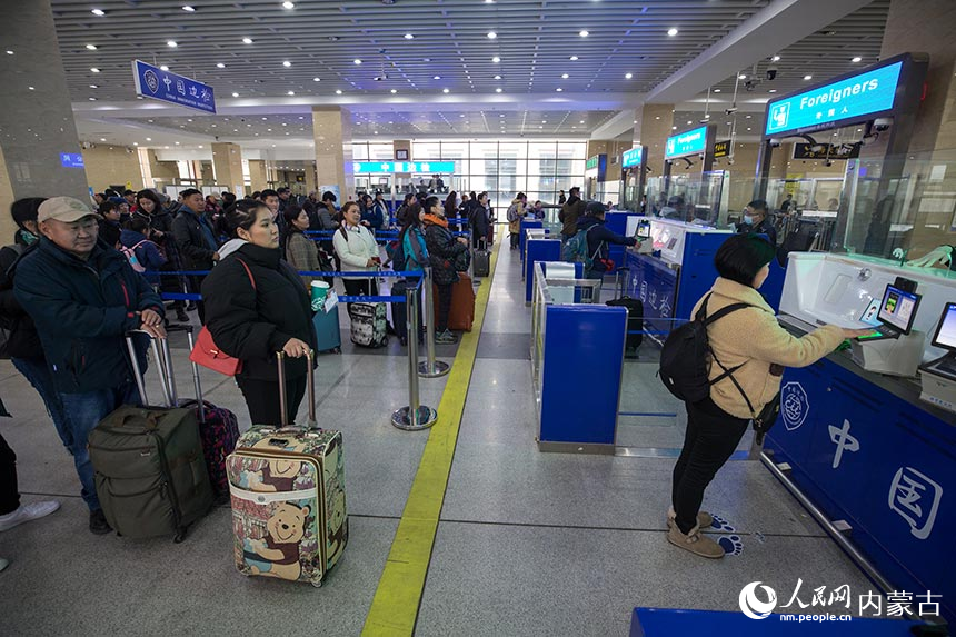 二連出入境邊防檢查站民警為旅客辦理通關(guān)手續(xù)。郭鵬杰攝