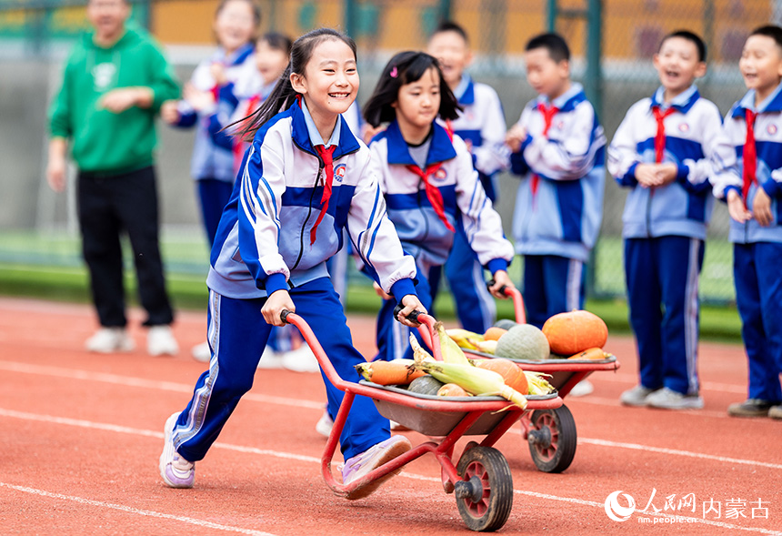 呼和浩特市玉泉區(qū)通順街小學(xué)學(xué)生在進(jìn)行秋收作物運(yùn)輸比賽。丁根厚攝