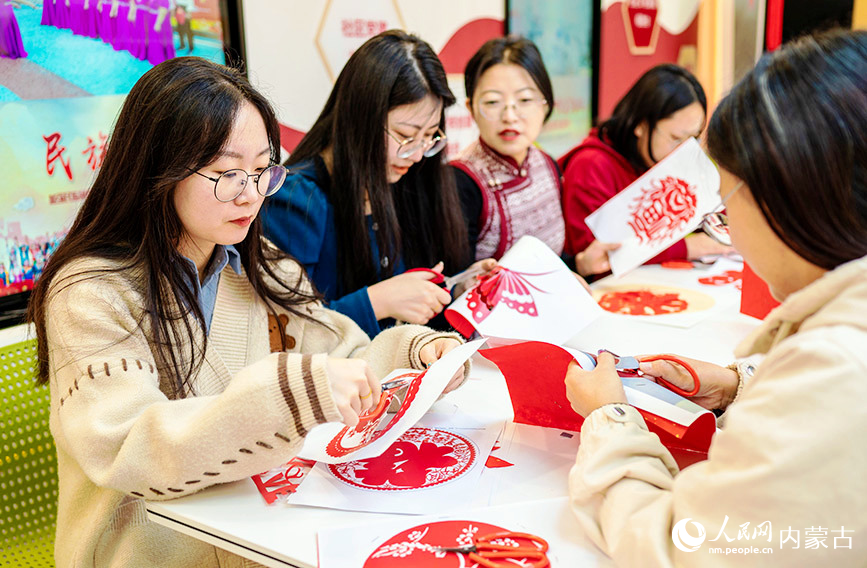 11月7日，工作人員在呼和浩特市玉泉區(qū)清泉街社區(qū)迎立冬主題活動現(xiàn)場制作窗花剪紙作品。丁根厚攝