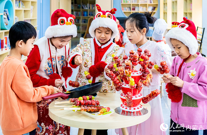 呼和浩特市玉泉區(qū)南柴火市街小學(xué)學(xué)生在學(xué)習(xí)制作糖葫蘆。丁根厚攝