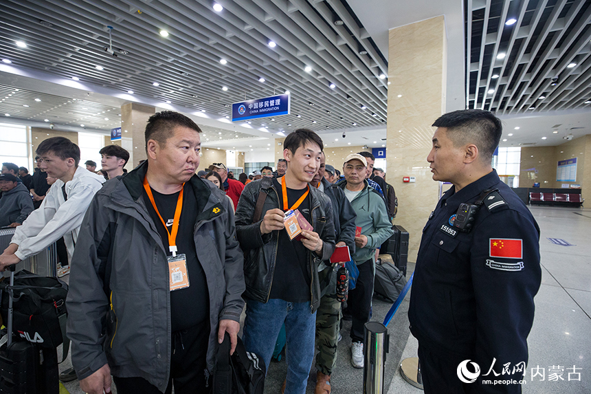 二連出入境邊防檢查站移民管理警察為旅客提供通關(guān)咨詢。郭鵬杰攝
