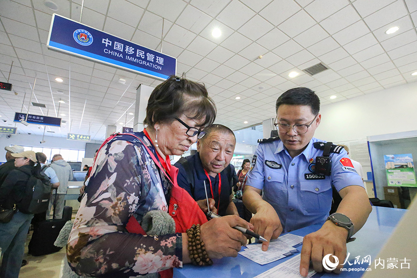 二連出入境邊防檢查站移民管理警察為參加“一帶一路·光明行”的蒙古國患者提供通關(guān)咨詢。楊金燁攝