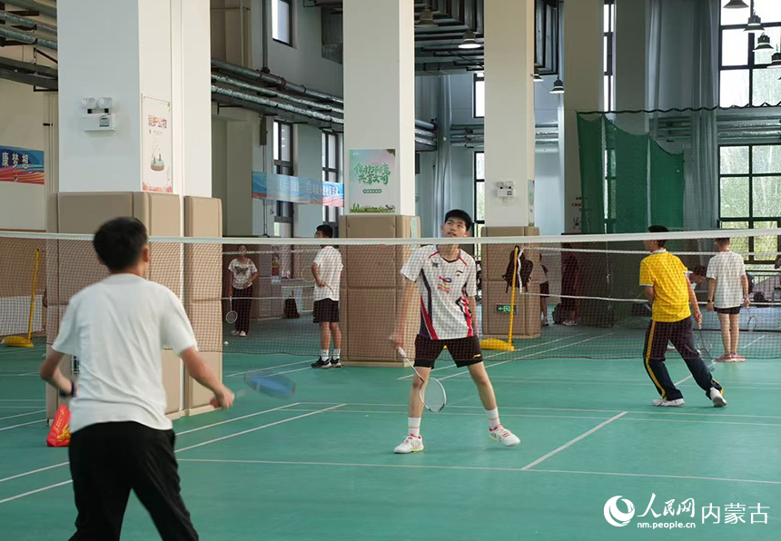 孩子們?cè)谏鐓^(qū)羽毛球場館打羽毛球。人民網(wǎng)記者 張力洋攝