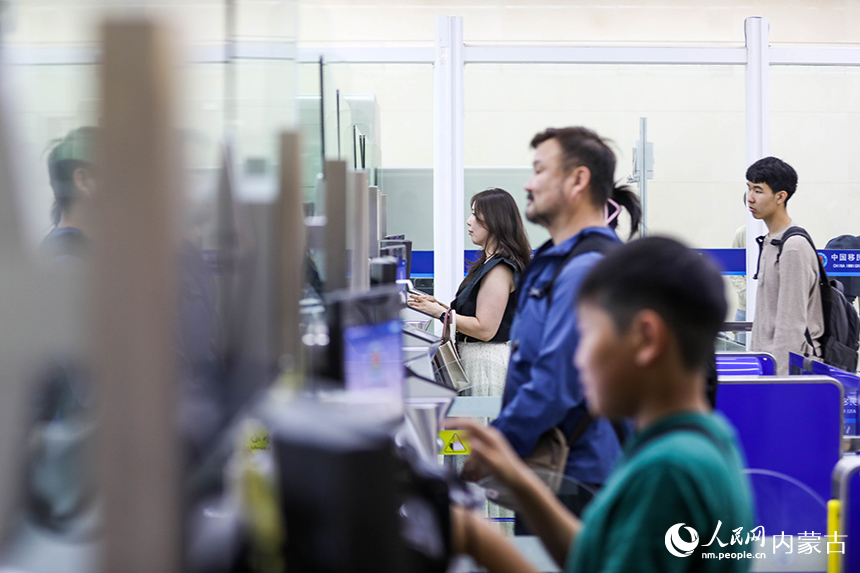 二連出入境邊防檢查站移民管理警察為入境航班旅客辦理通關(guān)手續(xù)。楊金燁攝
