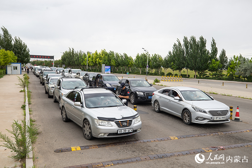二連出入境邊防檢查站移民管理警察為旅客辦理通關(guān)手續(xù)。郭鵬杰攝