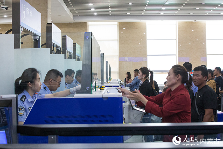 二連出入境邊防檢查站移民管理警察為旅客辦理通關(guān)手續(xù)。郭鵬杰攝
