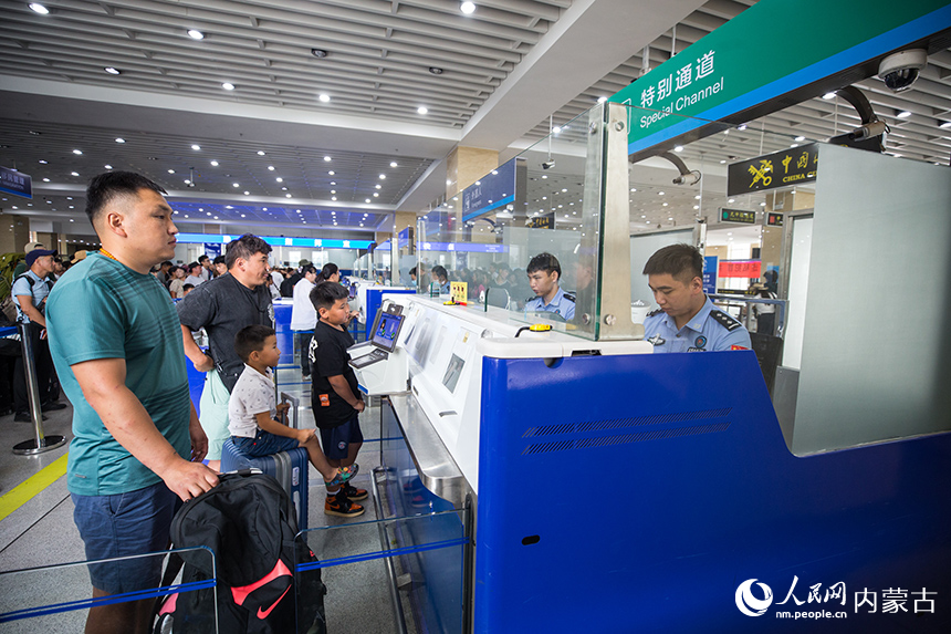 二連出入境邊防檢查站移民管理警察為旅客辦理通關(guān)手續(xù)。郭鵬杰攝