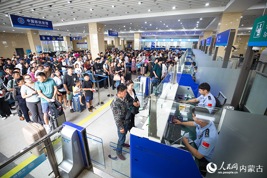 二連出入境邊防檢查站移民管理警察為旅客辦理通關(guān)手續(xù)。郭鵬杰攝