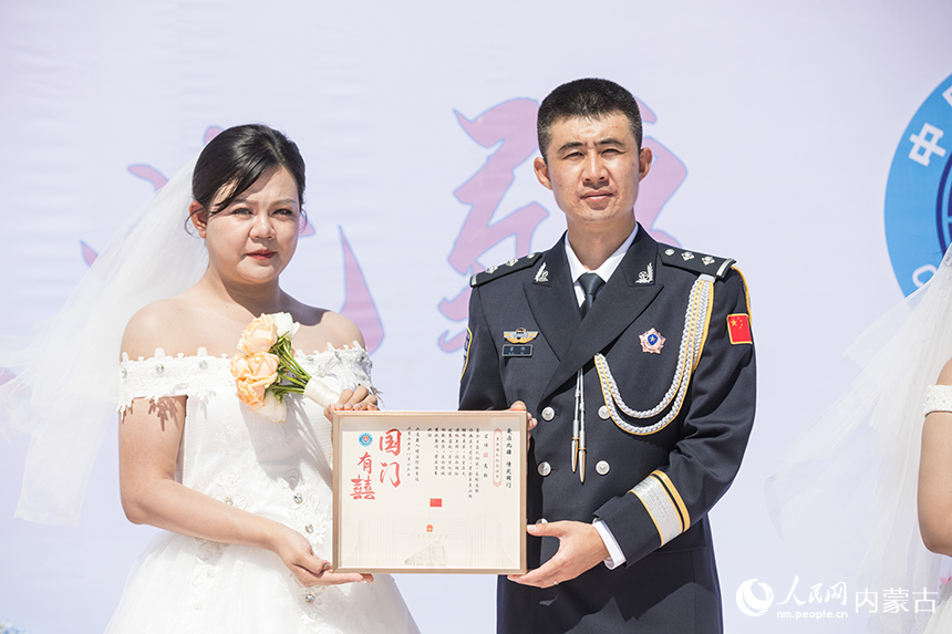 一對(duì)新人展示集體婚禮紀(jì)念證書(shū)。郭鵬杰攝