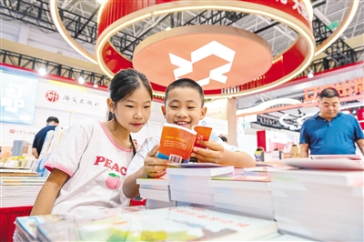 8月27日，小朋友在北疆書展現(xiàn)場閱讀書籍。記者 王磊攝