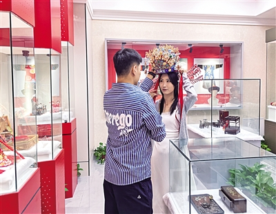 今年七夕，在呼和浩特市玉泉區(qū)婚俗博物館，新人試戴鳳冠。