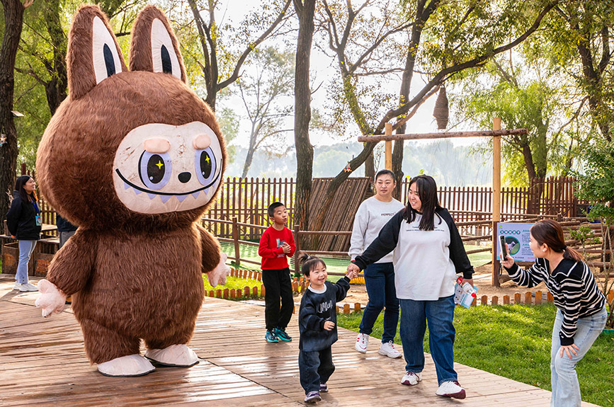 10月4日，呼和浩特市玉泉區(qū)林下郊野萌寵樂園，家長(zhǎng)給孩子與拉布布人偶拍照留影。丁根厚攝