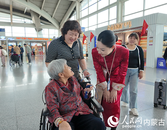 呼和浩特白塔國際機場工作人員為旅客贈送節(jié)日出行紀念品。內(nèi)蒙古自治區(qū)交通運輸廳供圖