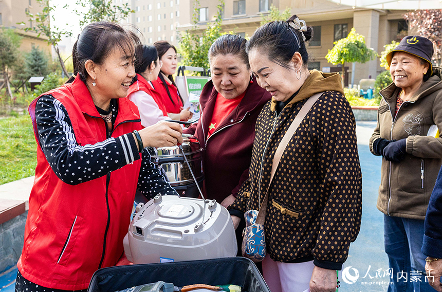 呼和浩特市玉泉區(qū)“文明市集”主題活動現(xiàn)場，志愿者在為社區(qū)居民修理小家電。丁根厚攝
