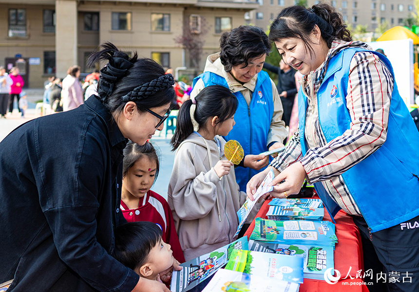 呼和浩特市玉泉區(qū)“文明市集”主題活動現(xiàn)場，科普志愿者在向居民普及科學(xué)知識。丁根厚攝