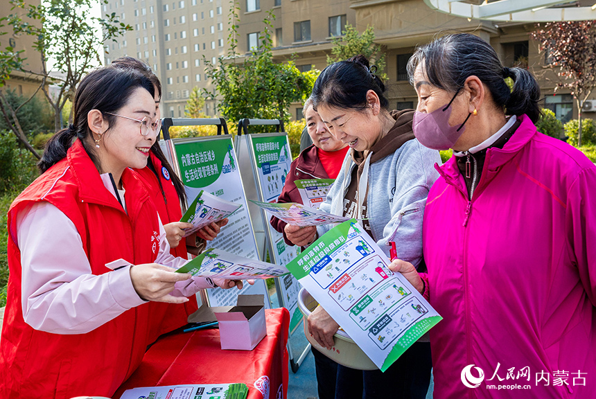 呼和浩特市玉泉區(qū)“文明市集”主題活動現(xiàn)場，志愿者向居民普及垃圾分類的相關(guān)知識。丁根厚攝