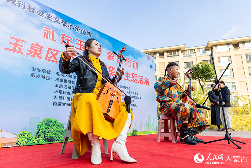 呼和浩特市玉泉區(qū)“文明市集”主題活動(dòng)現(xiàn)場(chǎng)，烏蘭牧騎隊(duì)員在為社區(qū)居民表演馬頭琴演奏。丁根厚攝