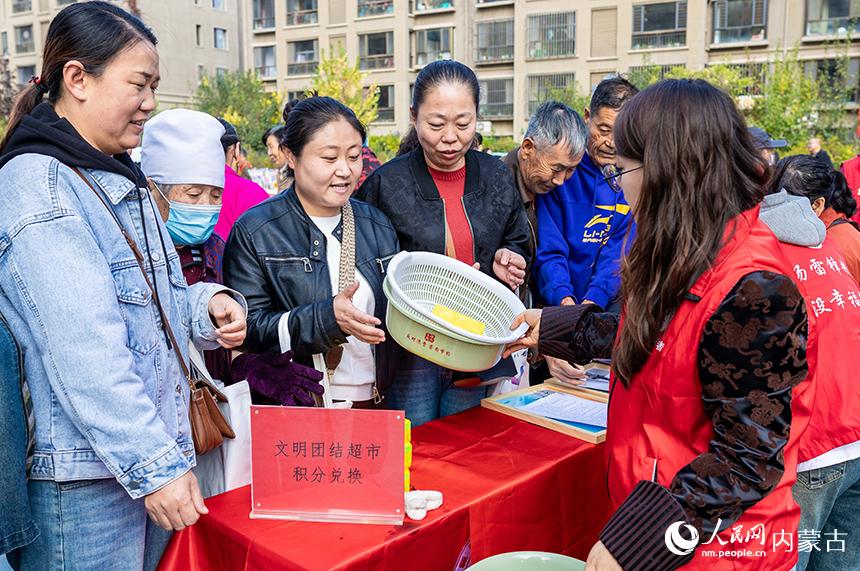 呼和浩特市玉泉區(qū)“文明市集”主題活動(dòng)現(xiàn)場(chǎng)，社區(qū)居民用平日積攢的“民族團(tuán)結(jié)積分”兌換日用品。丁根厚攝