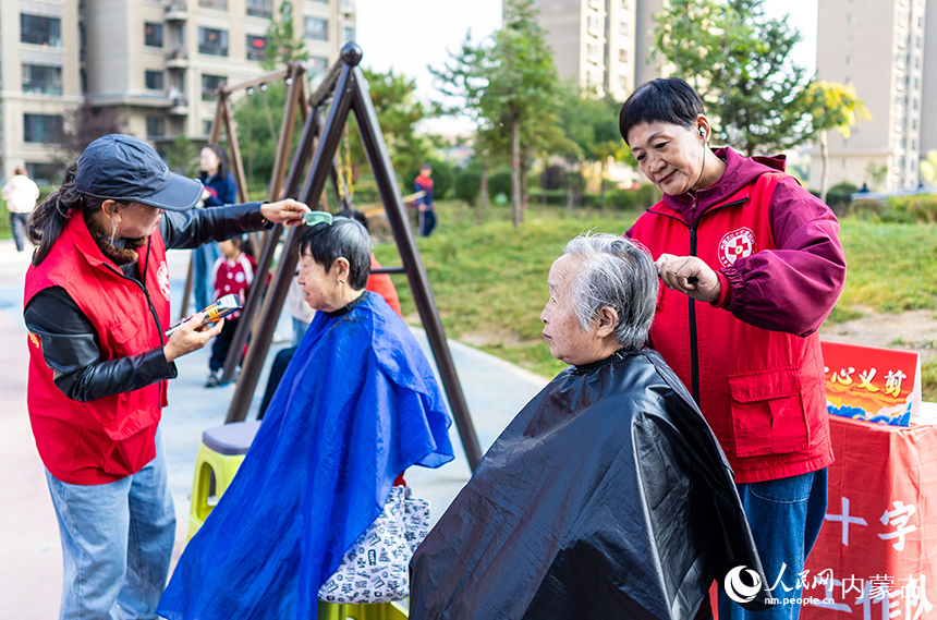 呼和浩特市玉泉區(qū)“文明市集”主題活動(dòng)現(xiàn)場(chǎng)，內(nèi)蒙古紅十字仁愛(ài)媽媽志愿服務(wù)隊(duì)隊(duì)員為居民義剪。丁根厚攝