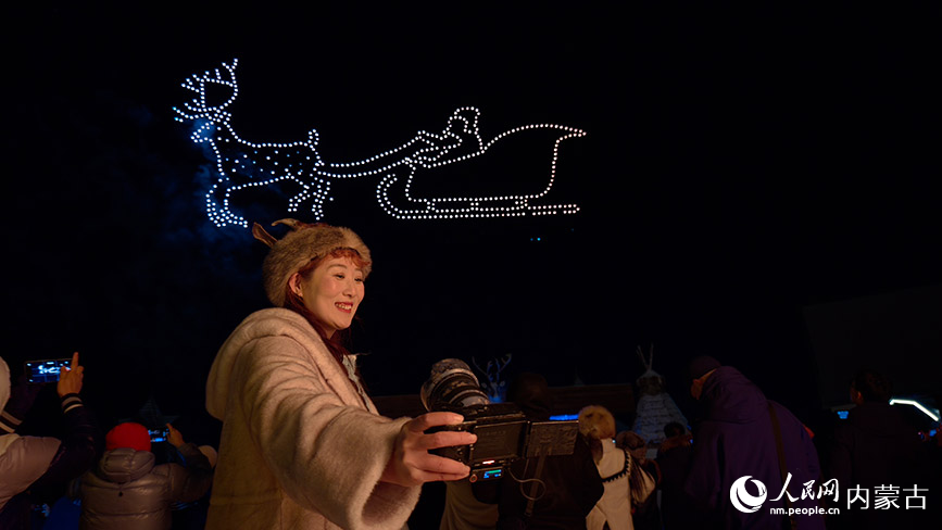 11月6日，呼倫貝爾市根河市的敖魯古雅廣場，游客在無人機(jī)表演現(xiàn)場拍照留念。人民網(wǎng)記者 張力洋攝