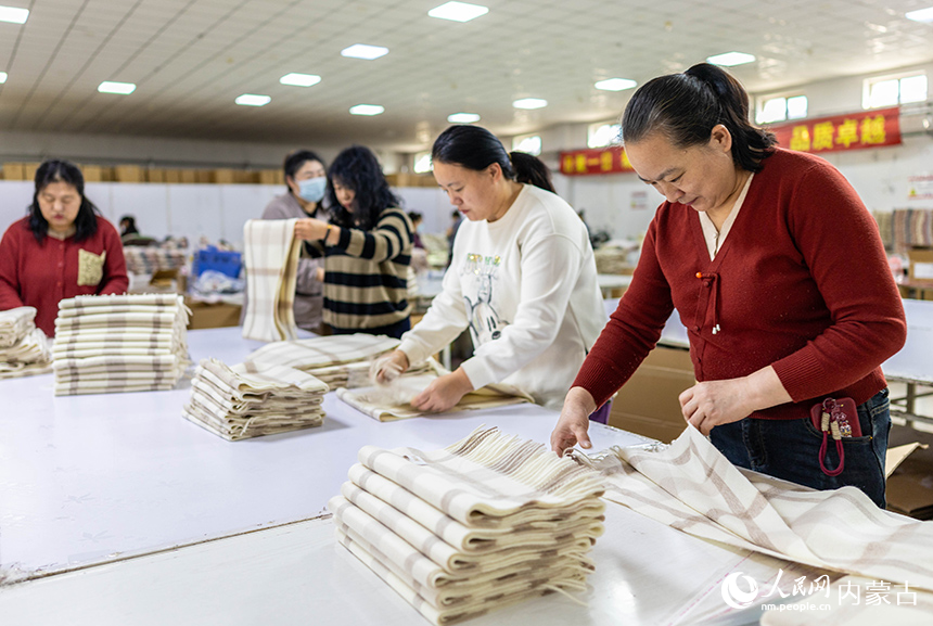 內(nèi)蒙古呼和浩特市玉泉區(qū)裕隆產(chǎn)業(yè)園精卓羊絨制品有限公司的生產(chǎn)車間內(nèi)，工人在生產(chǎn)線上趕制羊絨制品訂單。丁根厚攝