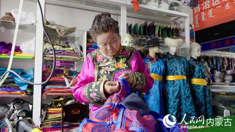 蒙古族服飾（巴林服飾）非遺代表性傳承人額爾燈塔那正在縫制蒙古袍。人民網(wǎng)記者 張力洋攝