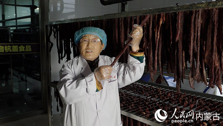 白秀枝在非遺工坊的晾曬車間展示風干中的牛肉干。李旭明攝