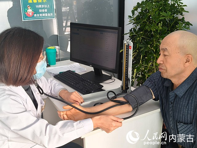 內(nèi)蒙古呼和浩特賽罕區(qū)金豐社區(qū)衛(wèi)生服務(wù)站為居民測量血壓。實(shí)習(xí)生 漸溫婷攝