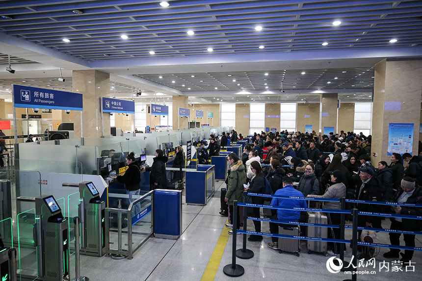 二連出入境邊防檢查站移民管理警察為旅客辦理入境手續(xù)。郭鵬杰攝