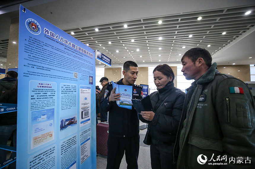 二連出入境邊防檢查站移民管理警察為旅客講解外國人入境卡網(wǎng)上填報(bào)流程。郭鵬杰攝