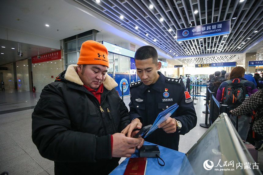 二連出入境邊防檢查站移民管理警察協助蒙古國旅客網上填報外國人入境卡。郭鵬杰攝
