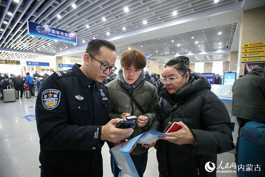 二連出入境邊防檢查站移民管理警察協(xié)助蒙古國(guó)旅客網(wǎng)上填報(bào)外國(guó)人入境卡。郭鵬杰攝