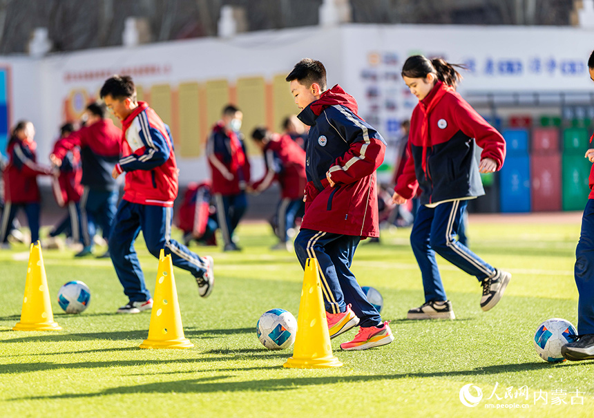 內(nèi)蒙古呼和浩特市玉泉區(qū)石東路小學(xué)的學(xué)生在操場(chǎng)上進(jìn)行足球技能訓(xùn)練。丁根厚攝