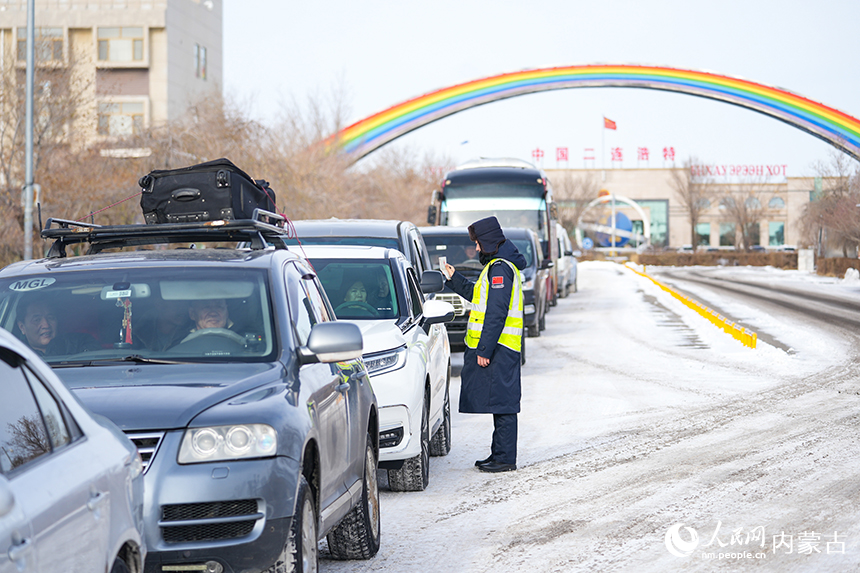 內(nèi)蒙古出入境邊防檢查總站二連出入境邊防檢查站移民管理警察正在查驗入境旅客證件。楊金燁攝