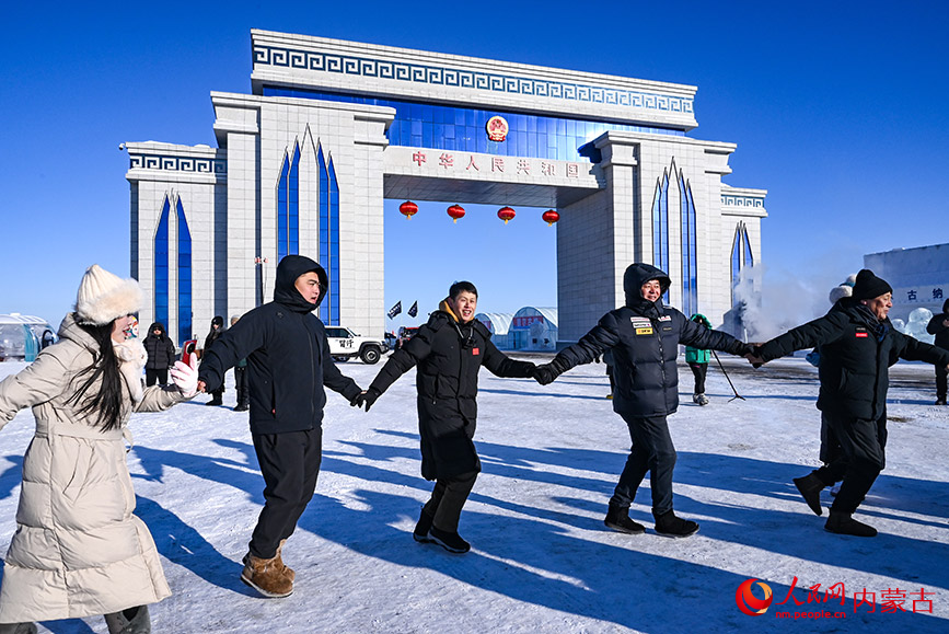 游客們?cè)趪?guó)門(mén)前手拉手歡歌載舞，每個(gè)人的臉上都洋溢著快樂(lè)的笑容。實(shí)習(xí)生 劉迎雪攝