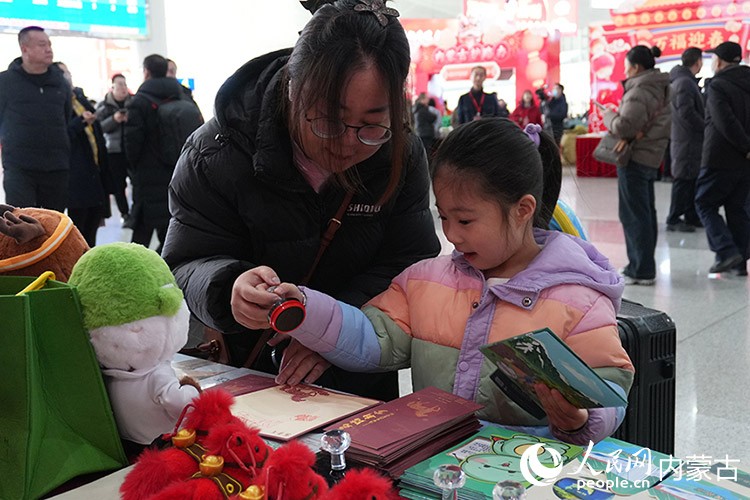 旅客在內(nèi)蒙古自然博物館展臺前打卡互動(dòng)。人民網(wǎng)記者 苗陽攝