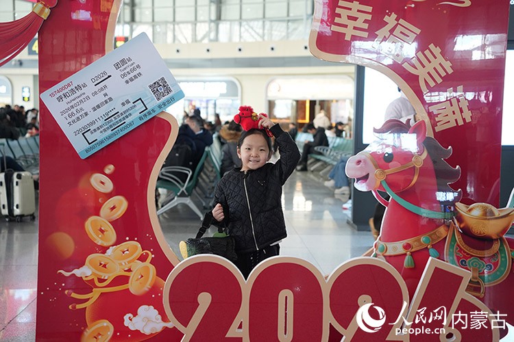 小朋友拿著馬年紀(jì)念品打卡拍照。人民網(wǎng)記者 趙夢月攝