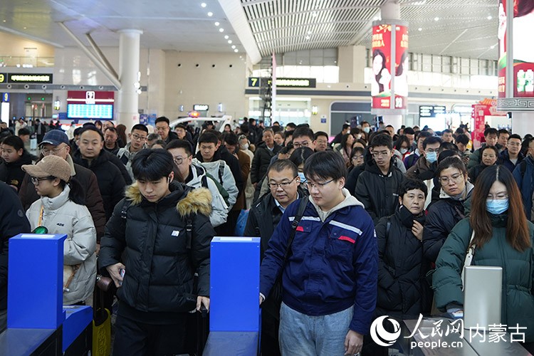 春運(yùn)首日，旅客在呼和浩特東站排隊(duì)乘車。人民網(wǎng)記者 趙夢月攝