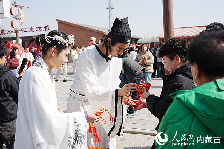 游客正在和現(xiàn)場演職人員互動(dòng)。人民網(wǎng)記者 苗陽攝