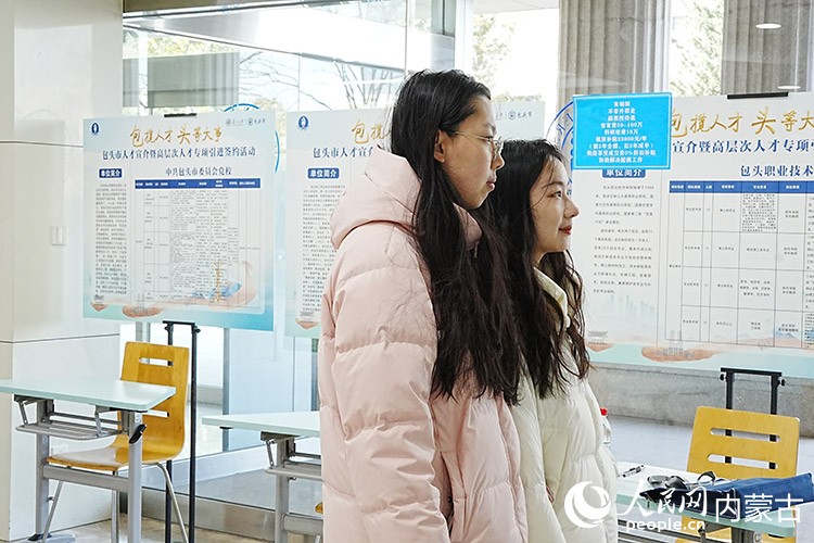 學(xué)生馬璟鈺（左一）和楊洋跨校區(qū)來到活動現(xiàn)場，了解回家鄉(xiāng)發(fā)展的機(jī)會。人民網(wǎng)記者 苗陽攝